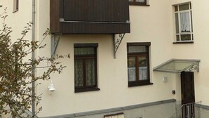 A two-story building with a balcony, multiple windows, and a satellite dish. - Ferienwohnung Herrmann (Weischlitz)