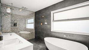 Bathtub, rainfall showerhead, hair dryer, towels