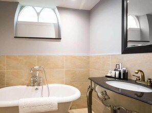 Un baño con bañera, lavabo y espejo.