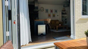 Ein modernes Wohnzimmer mit einer Schiebeglastür, die in einen Wohnbereich, eine Küche und einen Essbereich führt.