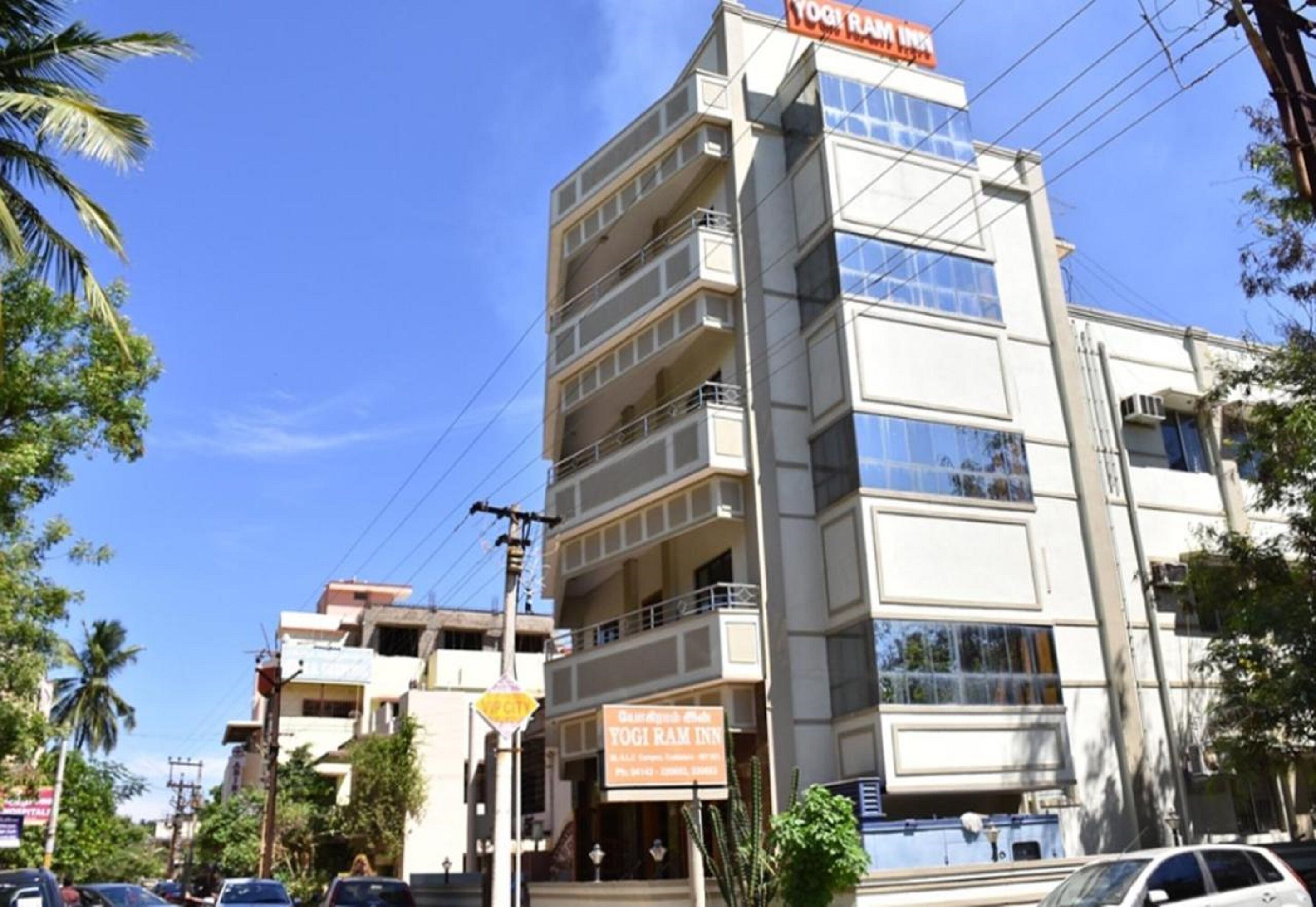A multi-story building with a sign for 'Yogi Ram Inn' on the top.