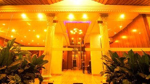 A grand lobby with a high ceiling, chandeliers, and columns. - JJS PARK INN (Chennai)
