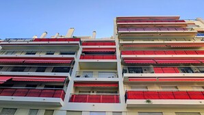 A multi-story building with balconies, each with red awnings. - N&J - SUNRISE TERRACE - Close sea - Terrace 30m² (Niza)