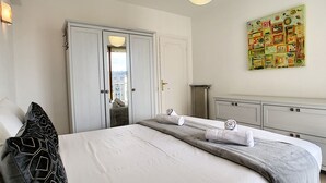 A bedroom with a bed, a wardrobe, a radiator, and a painting on the wall. - N&J - SUNRISE TERRACE - Close sea - Terrace 30m² (Niza)