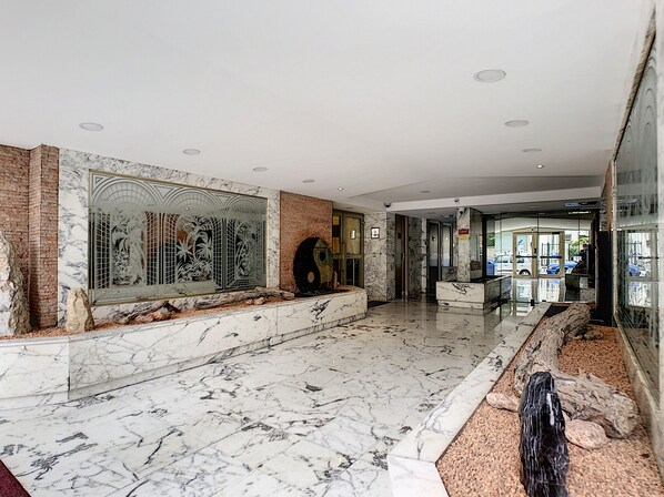 A spacious lobby with marble flooring, a large decorative wall, and a modern reception area. - N&J - SUNRISE TERRACE - Close sea - Terrace 30m² (Niza)