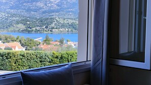 Una habitación con vista a un lago, montañas y un puente.