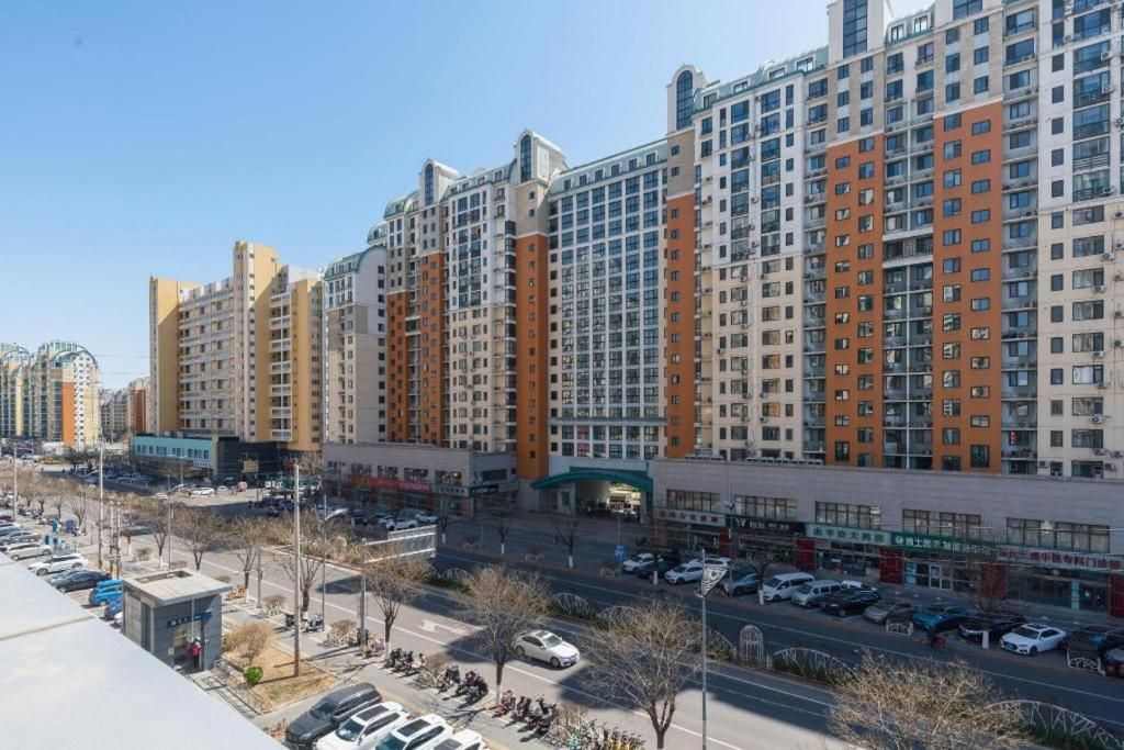 Un edificio residencial de varios pisos con un patio central, estacionamiento y locales comerciales en la planta baja.