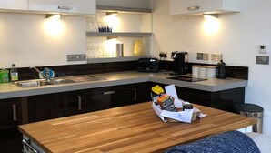 A modern kitchen with a wooden island, stainless steel appliances, and a built-in oven. - Luxury duplex flat in central Falmouth with parking (Falmouth)