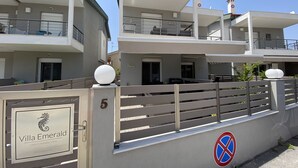 A modern multi-story building with balconies, a gated entrance, and a no-parking sign. - Villa Emerald - brand new house few minutes from the beach (Nikiti, Sithonia)
