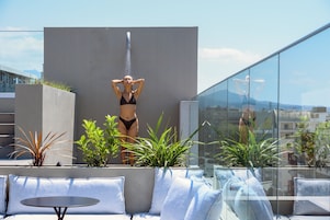 Una piscina al aire libre de temporada, sombrillas