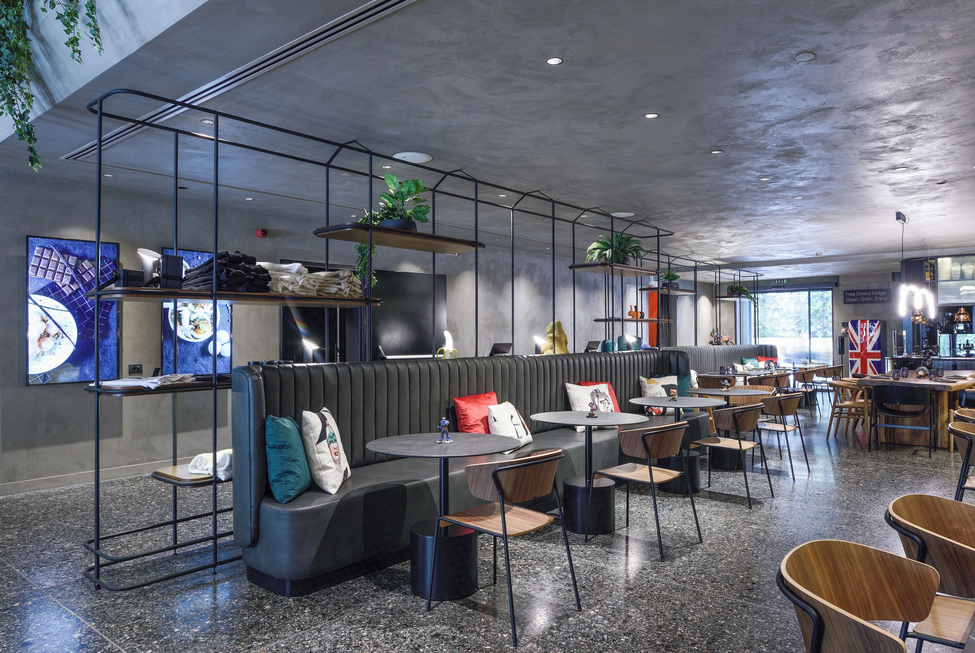 A modern restaurant with seating arrangements, including a bar area, and a visible menu board.