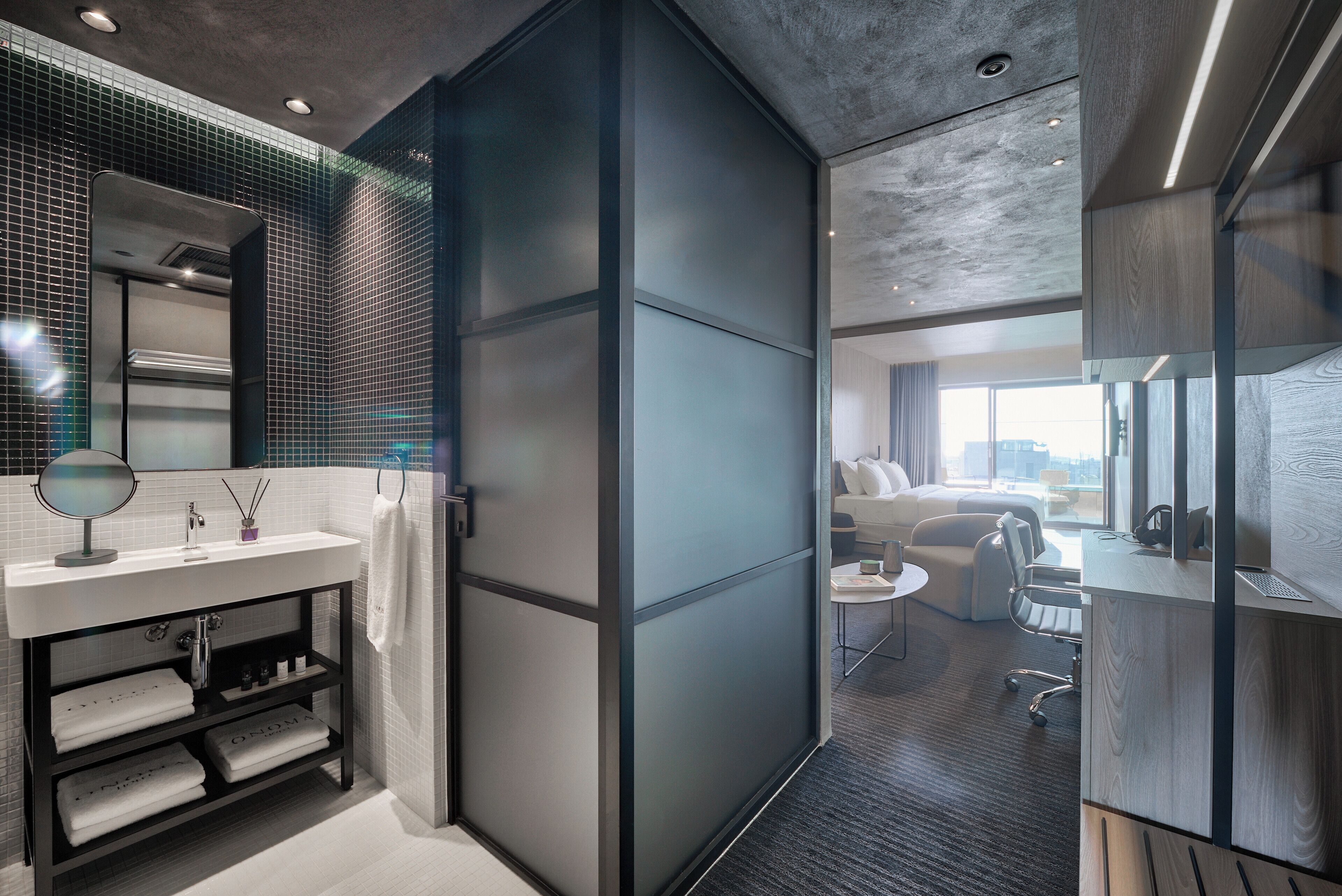 Un baño moderno con tocador, espejo y perchero.