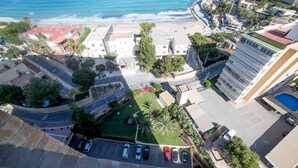 An aerial view of a coastal residential area with buildings, a road, and a beach. - Apartment Coblanca 16 (Benidorm)