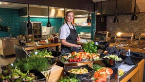 A buffet setup with various food items and a person standing behind the counter. - Thorbjørnrud Hotell (Jevnaker)