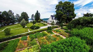 A large house with a well-maintained garden and a pathway leading to the entrance. - Thorbjørnrud Hotell (Jevnaker)
