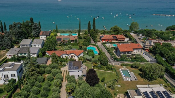 An aerial view of a residential area with houses, a swimming pool, and a marina with boats.