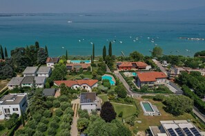 Eine Vogelperspektive eines Wohngebiets mit Häusern, einem Schwimmbad und einem Yachthafen mit Booten.
