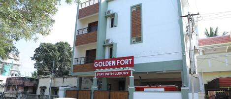 A building with a sign reading "Golden Fort Stay with Luxury".