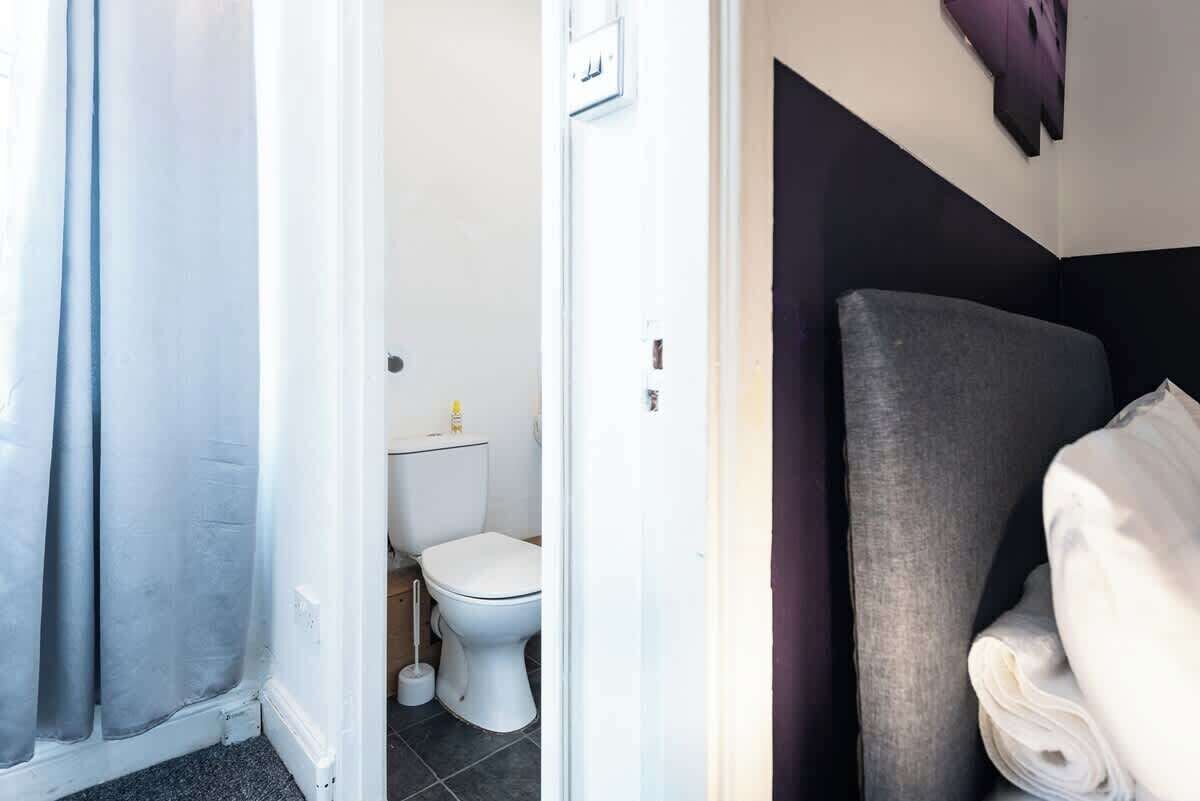A bathroom with a toilet, a sink, and a shower curtain.