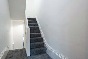 A staircase with carpeted steps leading to a door. - Hull Largest 6 Bedrooms House - Sleeps 13 (Hull)