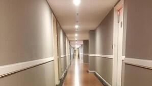 A long, narrow hallway with a wooden floor and grey walls. - Home Inn Hotel Beijing West North Plaza (Beijing)