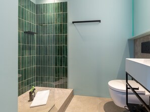 A modern bathroom with a shower area, a toilet, and a sink.