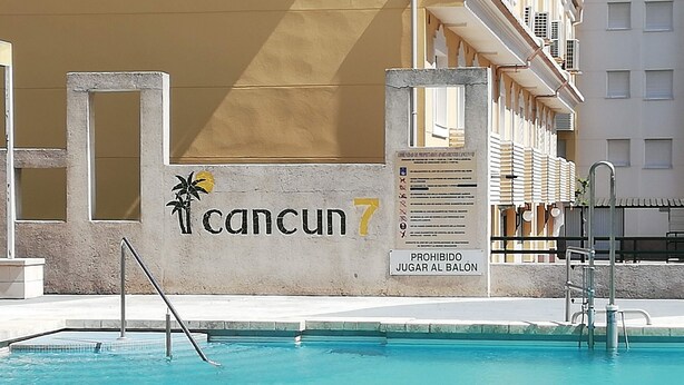 A swimming pool with a sign that reads 'Cancun 7' and a prohibition sign for playing in the pool. - CANCUN VII 6º,  Solo Familias! (Playa de Gandía)