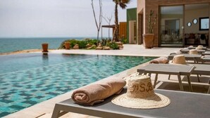 A poolside area with lounge chairs, a towel, and a hat.