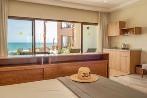 A hotel room with a view of the sea, a wooden desk, a hat, and a kitchenette. - Dakhla South Bay, WorldHotels Distinctive (Dakhla)