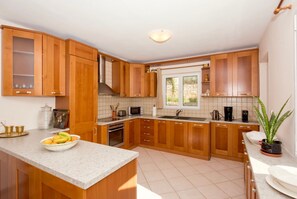 Enjoy cooking in this well-equipped kitchen with a large island, oven, and sink.