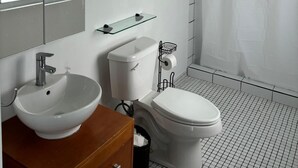 A modern bathroom with a white sink, toilet, and shower. - Casa Condado Hotel & Residences Rooftop Studio (San Juan)
