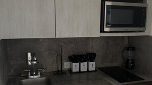 A kitchen with a built-in microwave, a sink, and a dishwasher. - Casa Condado Hotel & Residences Rooftop Studio (San Juan)