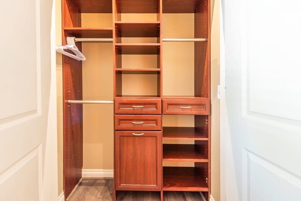 A walk-in closet with multiple shelves, drawers, and hanging space.