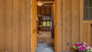 A wooden interior with a stone-tiled entrance, a kitchen area, and a dining space. - Fresh Tracks at Northstar- TLUXP (Truckee)