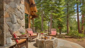 A stone exterior wall, wooden deck, Adirondack chairs, and a fire pit. - Fresh Tracks at Northstar- TLUXP (Truckee)
