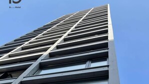 A modern building with a prominent 'Neko Yard' sign. - b hotel Neko Yard | Stylish Loft Studio Central (Hiroshima City)