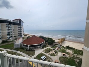 Un hotel frente al mar con vista a la playa, un pabellón y un paseo marítimo.