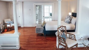 A spacious room with a bed, a chair, and a small table. - Modern Chic 1-BR Unit in the Cottages on James (Clayton)