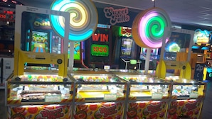 Een fel verlichte speelhal met diverse spelletjes en een ticketbalie.