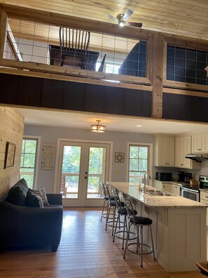 Spacious living area with mezzanine level, kitchen, and bar counter.
