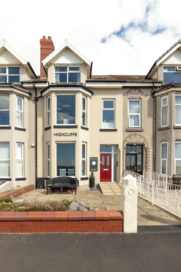 A row of townhouses with a prominent "HIGHCLIFFE" sign on the front.