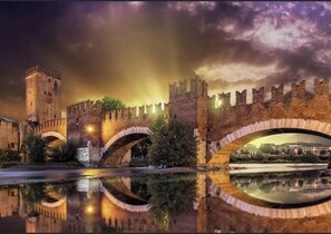 A historic stone bridge with arches, a tower, and a river reflecting the structure. - BED & BREAKFAST FABLAS, Borgo Trento - Verona (Verona)