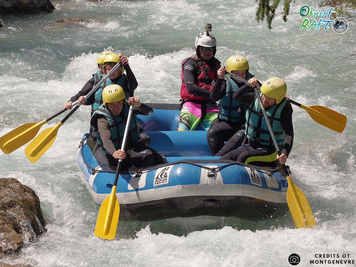 A group of people in a blue inflatable raft with yellow paddles, navigating through a river.