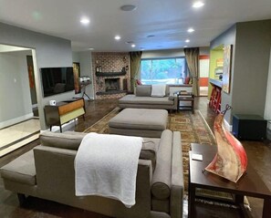 Relax in a cozy seating area with a fireplace, flat-screen TV, and comfortable sofas.