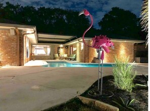 Relax by the pool surrounded by lush gardens and a unique pink flamingo sculpture.