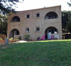 A two-story building with arched windows and a flat roof.