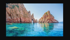 A coastal landscape with rocky cliffs and clear blue water. - Appartement vue mer et Montagne, à Létage (Calcatoggio)
