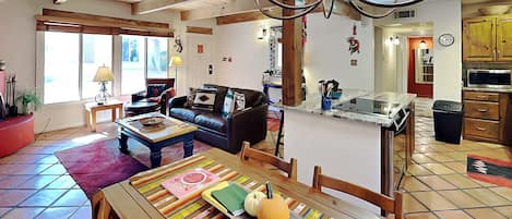 Ein großzügiger Wohnbereich mit Esstisch, Sofa und einer Küche im Hintergrund.