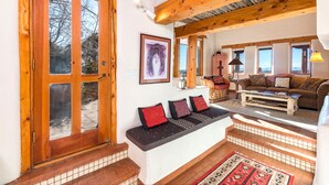 A cozy living room with a wooden bench, a sofa, and a coffee table. - City Views at Alma Compound | Great Location! (Santa Fe)