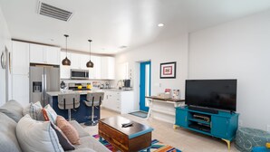 Un salon moderne avec un canapé, une table basse et un téléviseur posé sur un meuble.